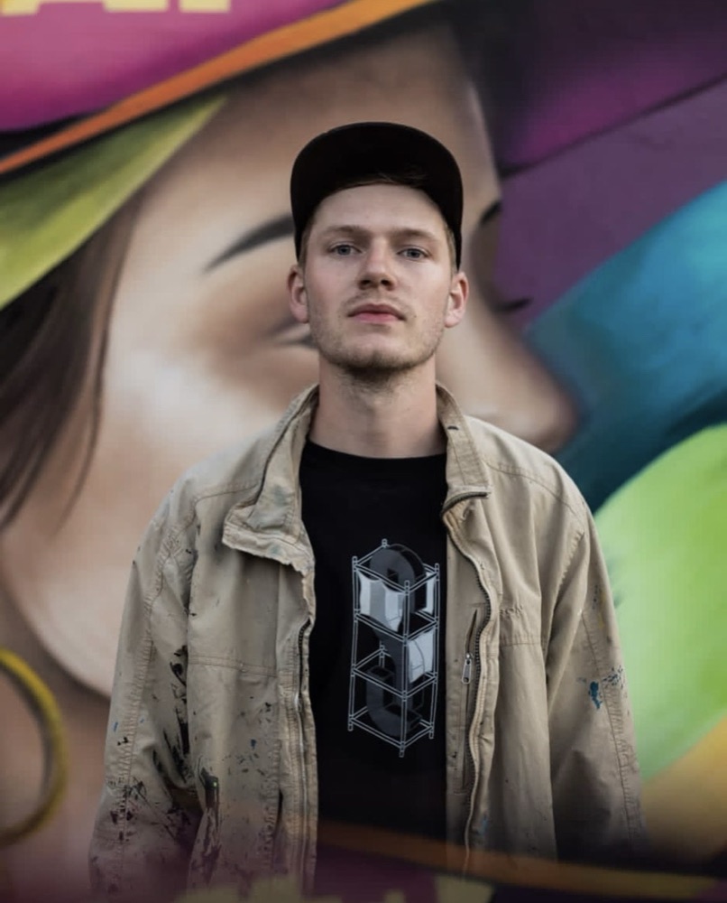 Justin, owner of Top Murals, in front of one of his murals